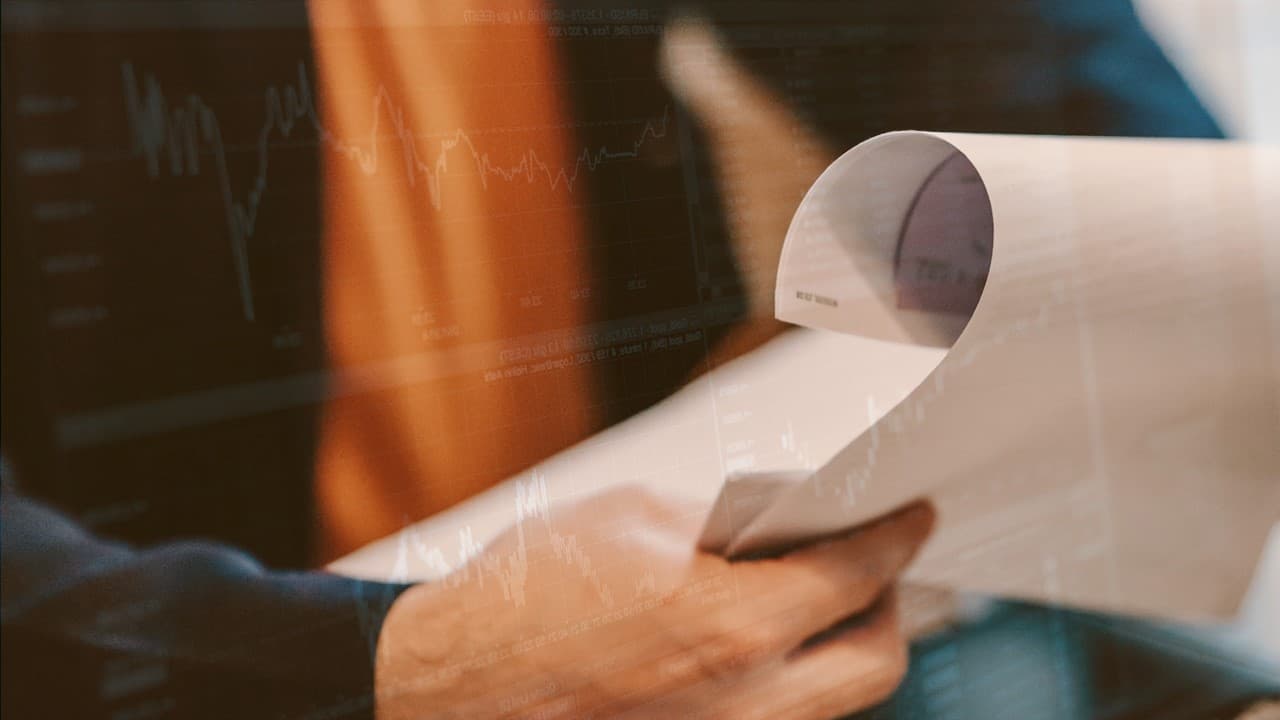 Man looking at documents with computer data overlayed as a graphic