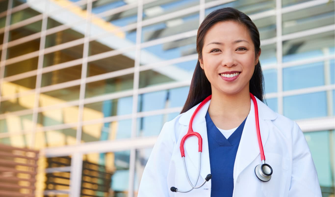 smiling doctor outside hospital building