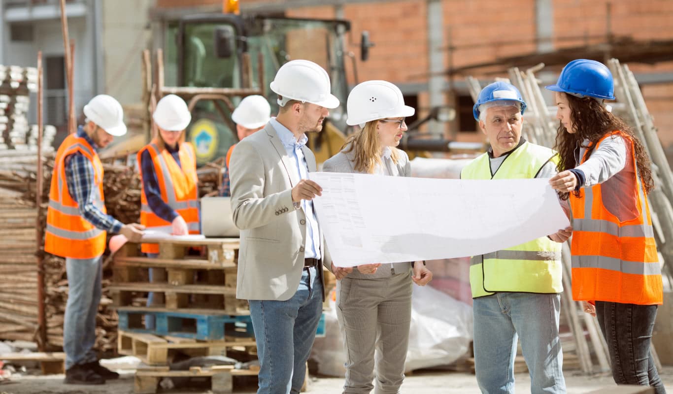construction workers looking at a paper plan