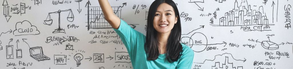 Asian teenage girl raising her hand in front of a whiteboard with doodles